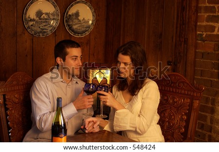 Young couple wine toasting at a romantic dinner country inn