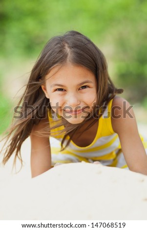 five-year-old girl lying on the beach