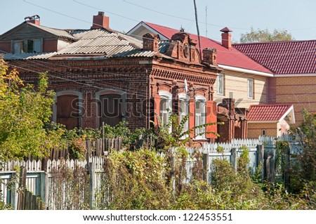 Old brick mansion with blue board fence. Gorodets, Nizhegorodsky region, Russia.