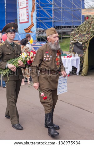 MOSCOW/RUSSIA - MAY 9: Old man veteran of WWII in uniform decorated with awards  looks for brother-soldiers during festivities devoted to 65th anniversary of Victory Day on May 9, 2010 in Moscow.