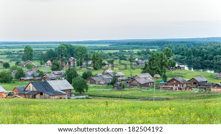 View on river valley with wooden village houses along riverside. Arkhangelsky region, Russia.