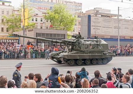 MOSCOW/RUSSIA - MAY 9: People on street side and Russian Army 2S19 Msta-S self-propelled 152 mm howitzer on display during parade festivities devoted to Victory Day on May 9, 2011 in Moscow.