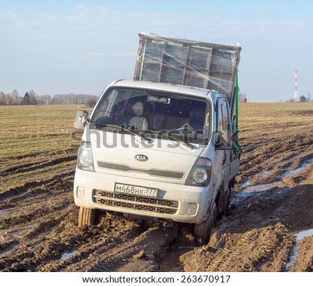 BULATOVO, KALUZHSKAYA REGION/RUSSIA - MARCH 9: Off-road truck with man in cab settles down in mud on dirty road in fallow field on March 9, 2015 in Bulatovo.