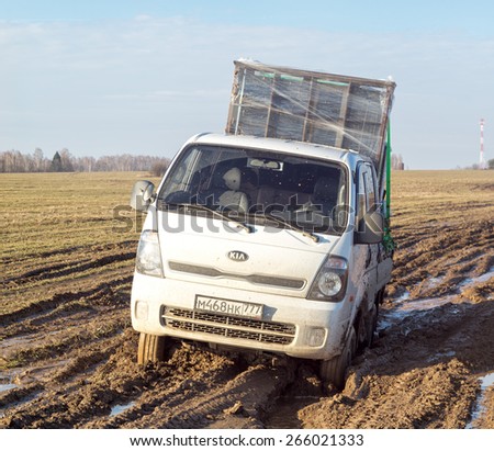 BULATOVO, KALUZHSKAYA REGION/RUSSIA - MARCH 9: Off-road truck with furniture settles down in mud on dirty road in fallow field on March 9, 2015 in Bulatovo.