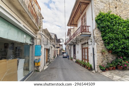 PANO LEFKARA, CYPRUS â?? MAY 1: Woman with kid move on street with old stonemason houses with balconies and flowers along. Fisheye view on May 1, 2015 in Pano Lefkara.