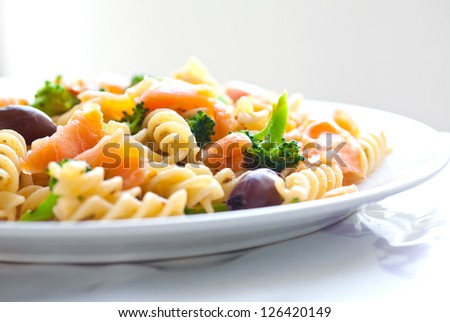 Plate of spiral pasta with smoke salmon and broccoli
