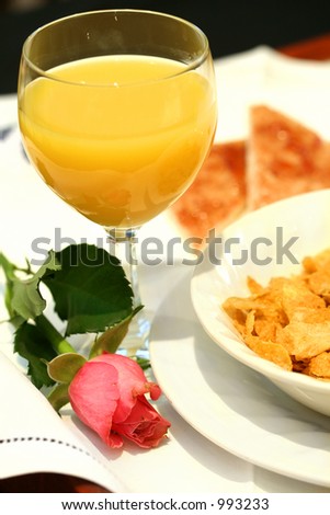 Romantic Surprise : A tray of breakfast comprising of a glass of orange juice, breakfast cereal, toast and a stalk of rose