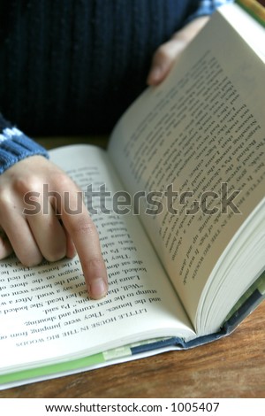 Reading : Index finger pointing on a paragraph of a book