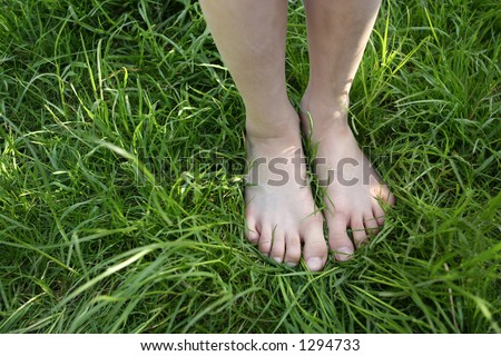 The grass is always greener : A pair of feet standing on lush green grass