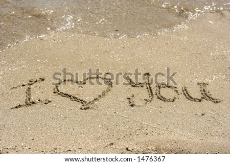 Carved in the sandy shore. \'\' I Love You \'\' written on sandy beach. Concept : My love as sure as the rising tides.
