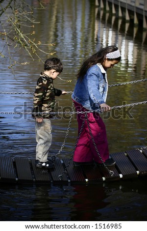 A boy crosses the little bridge lead by his sister. Concept:Love and Protection
