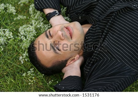 A young man laying in a field of white flowers