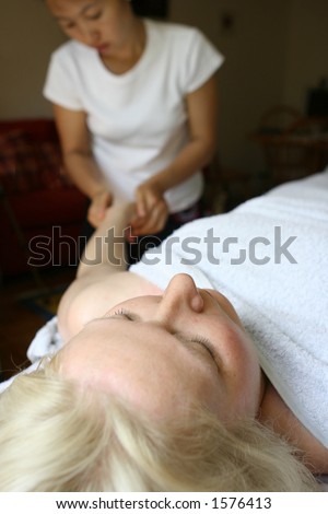 Arm massage - A therapist treating her client with holistic massage