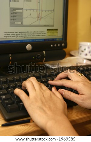 A pair of feminine hands on the computer keyboard