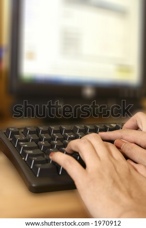 A pair of feminine hands at the computer keyboard, with blurred background.