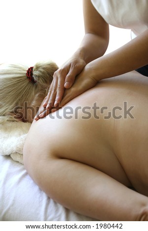 A masseur treating her client with holistic back massage