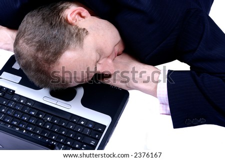 A businessman fallen asleep on his laptop, over white.