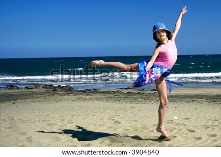 Young girl jumps up high on the sandy beach of the mediterranean coast.