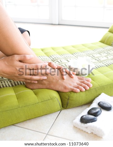 Woman pampering her feet, treating it with aroma therapy and therapy stones
