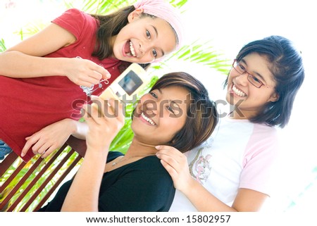Three female family members sharing information from a cellphone