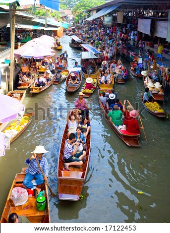 Bangkok August 2008.Wooden flat boats busy ferrying people at Damoen Saduak floating market. A traditional but popular method of buying and selling still practised in the canals of Bangkok Thailand.