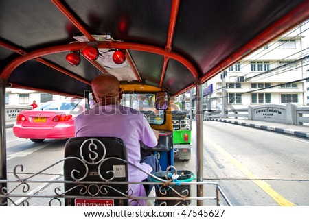 BANGKOK- JAN 20:  A tuk tuk negotiates a back street in the busy town Jan 20, 2010 in Bangkok.  These are motorized rickshaws and are popular amongst tourists for their novelty value.