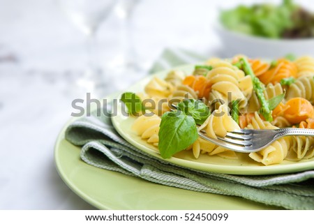 Colorful pasta with asparagus and rocket pesto and basil