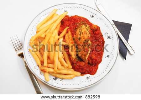 Dinner time, chicken fillet, sauce provencal, mushrooms,  tomatoes, onions, carrots,  garlic and chive on top for decoration. Served with french fries. Photographed over white,  white background.