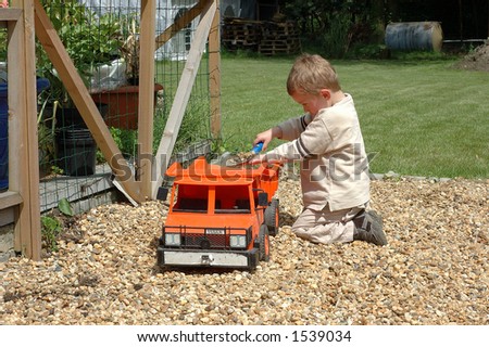 Toddler playing with toy in garden.  Youth concept.