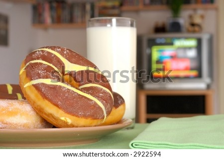 Having a snack on a television evening.  Various chocolate donuts. Food, nutrition,  relaxation, media concept.