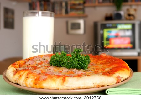 Having a snack on a television evening.  Pizza with parsley. Food, nutrition,  relaxation, media concept.