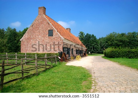 Rural belgium, historical preserved farm house against vibrant blue sky.  Vintage, architecture, culture concept.