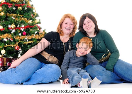 happy youngsters, teenage girls and one boy around Xmas, Christmas three with presents, gifts.  White background.