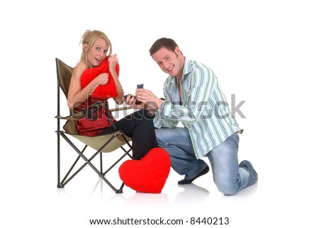 Two casual dressed young adults, teenage man and woman proposing. studio shot, reflective surface