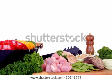 Wok cooking, cutting board with vegetables, meat, pepper mill on the side, reflective surface, studio shot