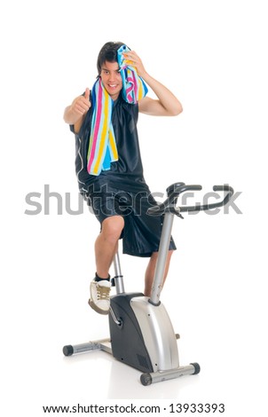 Young attractive male teenager on fitness bike, bicycle. Studio shot, white background.