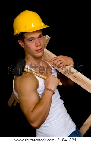 Young attractive male body builder, demonstrating artistic construction worker pose. Studio shot, black background.