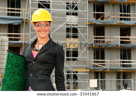 Attractive young smiling female architect, businesswoman in front of construction site.  studio shot.