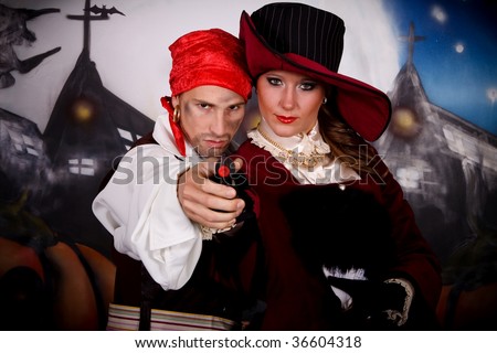 Young woman, Halloween lady with fancy hat and pirate holding gun. Studio, painted themed background.