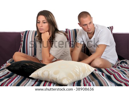young  couple having a depression, quarrel in the bedroom on bed.  Studio.