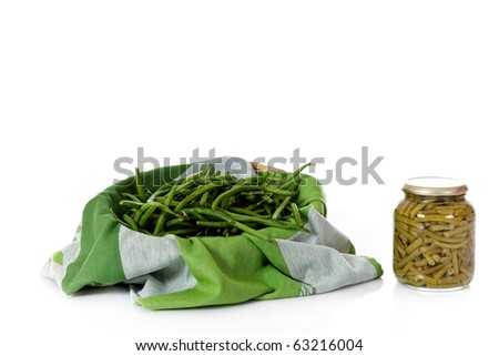Basket with fresh versus a jar with canned green beans. Studio shot. White background. Copy space.