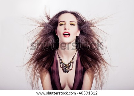studio portrait of a beauty young woman with wonderful long hairs in the wind