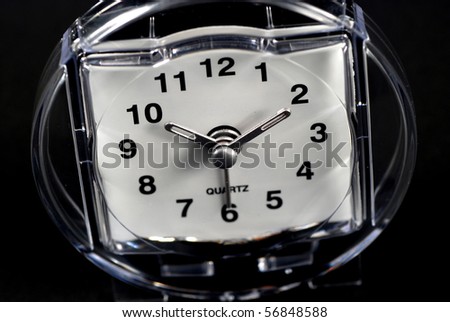 stock picture of a white face clock on black background