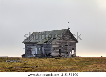 wooden hunting Lodge in open tundra, partially destroyed by hurricane