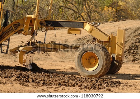 Large road grader working ground at a new commercial housing development
