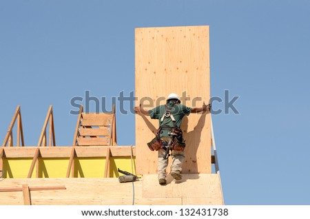 Construction crew working on the roof sheeting of a new, two story, commercial apartment building in Oregon