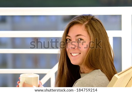Krystal Fox A young female adult drinks her morning tea on a balcony of a condo