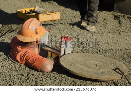 Excavation contractor entering a manhole while working on sanitary sewer system on a new commercial development