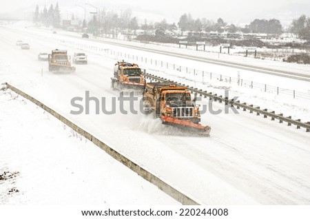 Snow plows clearing the freeway on Interstate 5 during a winter snow and freezing rain storm