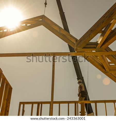 Roof truss company placing new home wood engineered trusses on a residential construction site